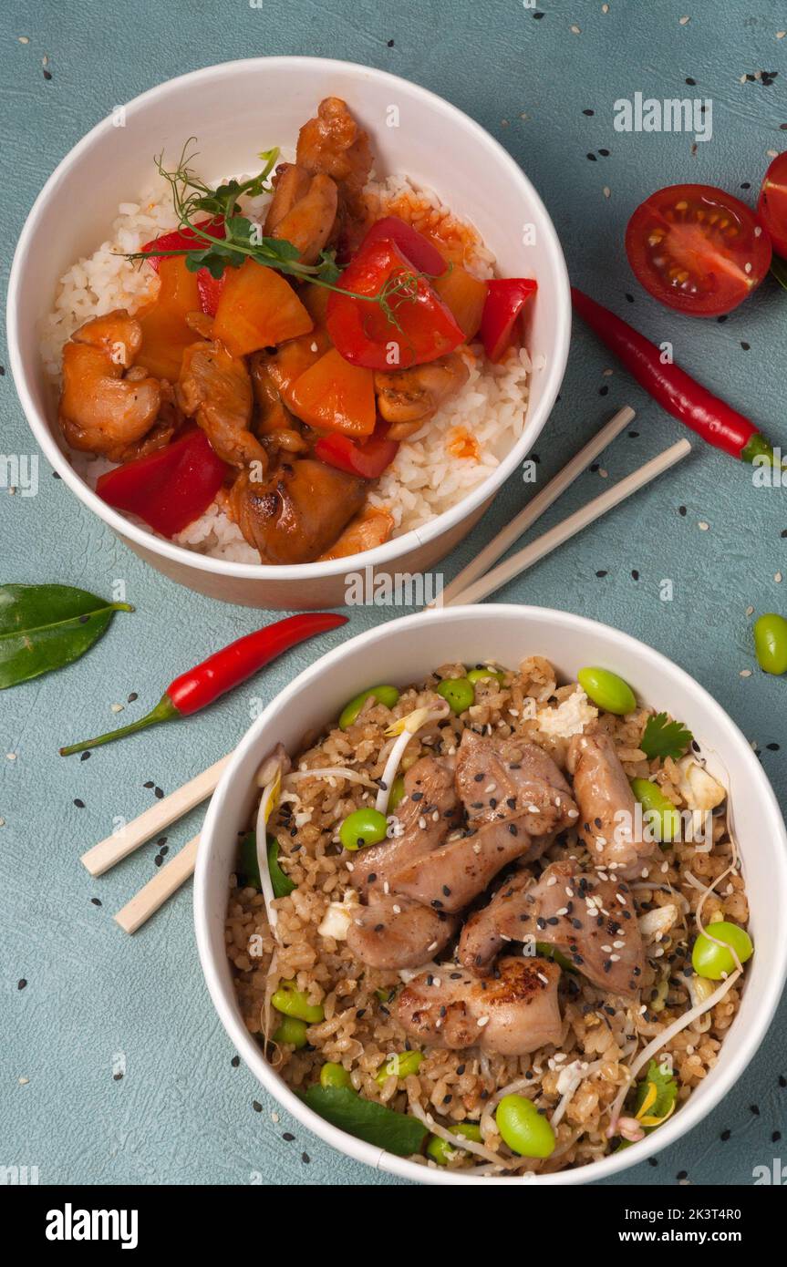 Ancora vita da gustoso cibo asiatico: Riso con pollo e verdure in salsa dolce e agrodolce e riso all'aglio con pollo Foto Stock