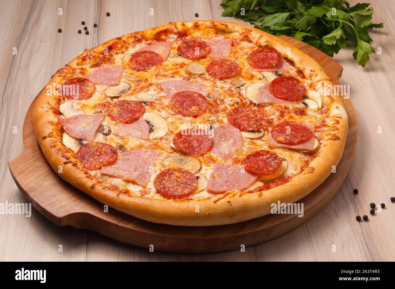 gustosa pizza con formaggio, prosciutto, peperoni e funghi Foto Stock