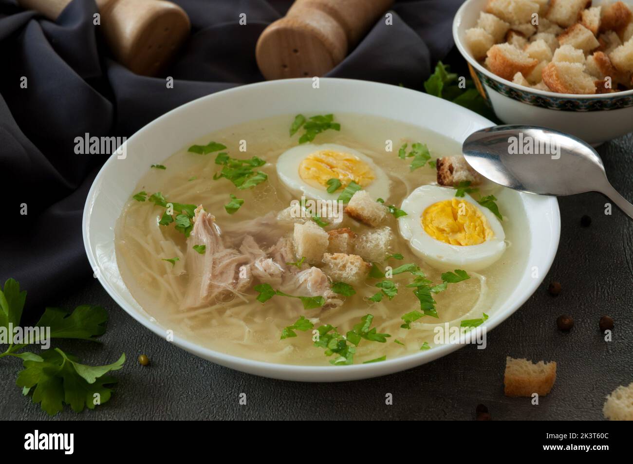 gustosa zuppa di pollo con tagliatelle, uova, erbe aromatiche e crostini Foto Stock