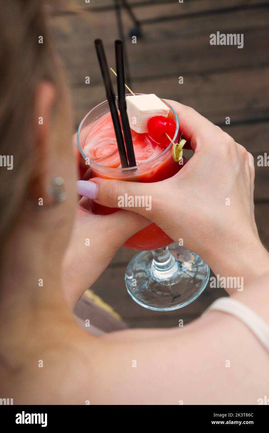 una donna yong beve un cocktail di pesca in un ristorante Foto Stock