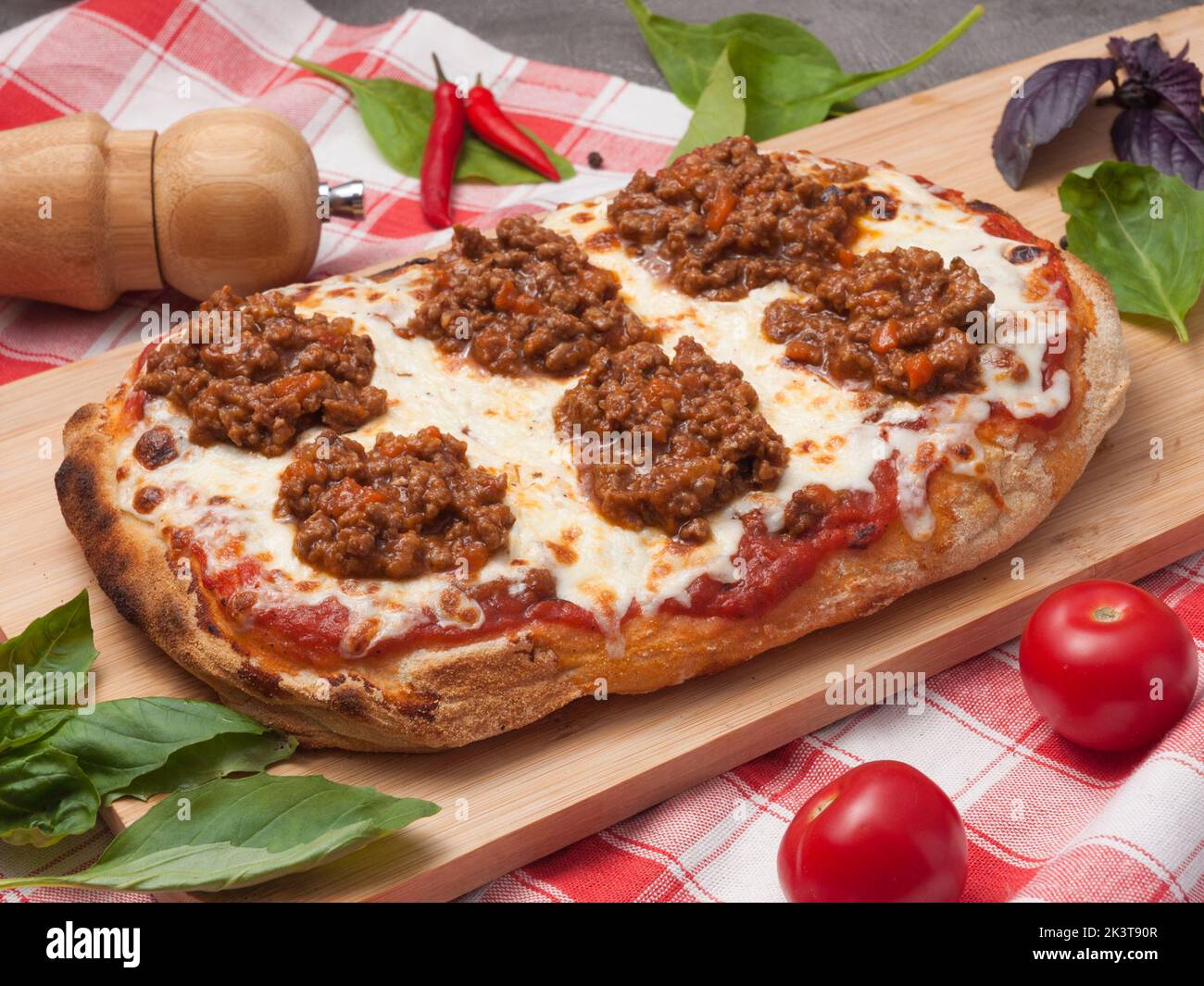 gustosa pizza bolognese romana su un asse di legno Foto Stock