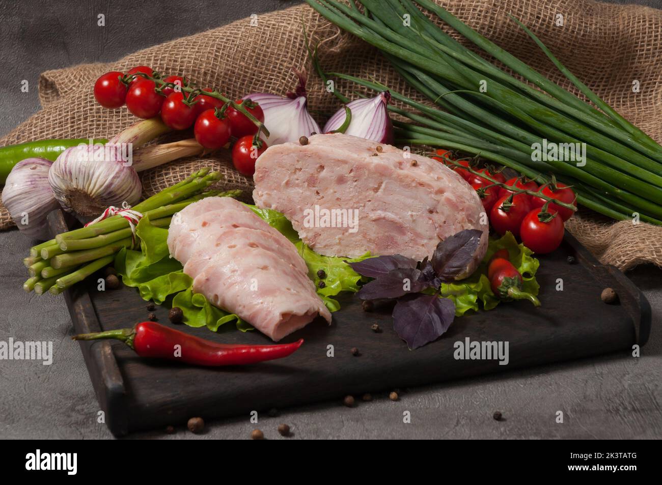 gustoso prodotto di salsiccia - carne pressata decorata con verdure fresche Foto Stock