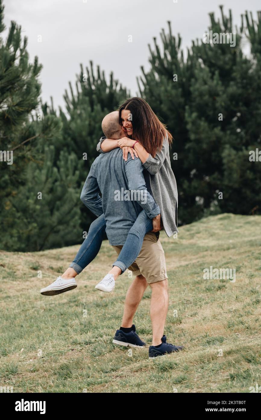 Vista laterale di una coppia amorevole che gioca in montagna Foto Stock