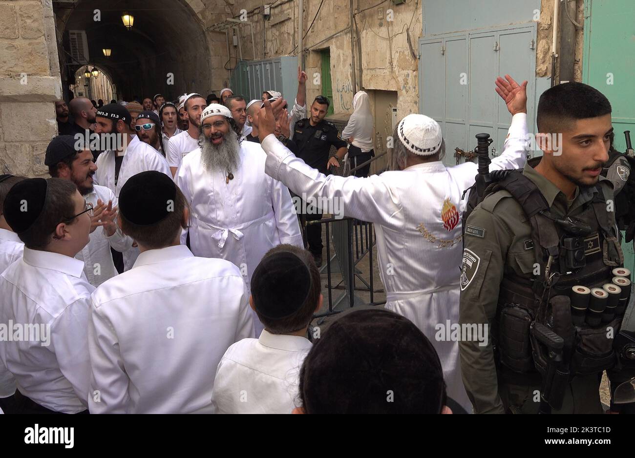 I membri delle forze di sicurezza israeliane sono in guardia mentre gli ebrei religiosi cantano e ballano dopo la loro visita al monte del Tempio nella via Chain Gate nella città vecchia il 27 settembre 2022 a Gerusalemme, Israele. Foto Stock