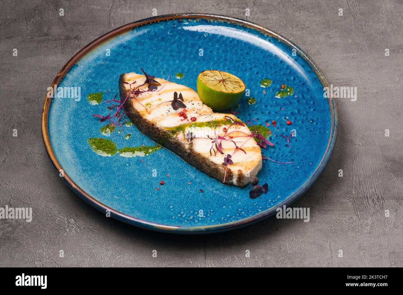 gustoso pesce bianco alla griglia con burro verde e lime Foto Stock