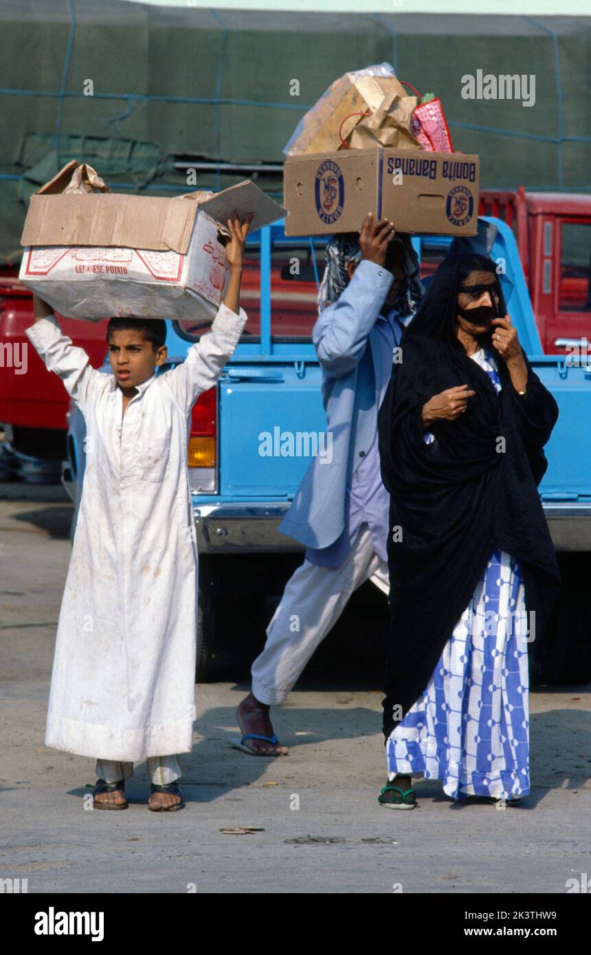 Dubai UAE Mother and Son Shopping in Souk scatole da trasporto in testa Foto Stock