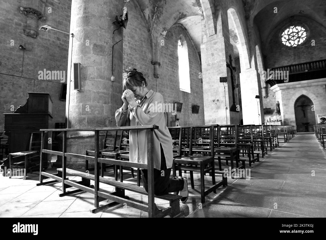 Donna cristiana che prega nella Chiesa di Sainte-Marie a Montreal nel dipartimento Lot-et-Garonne, Francia sudoccidentale. Montréal-du-Gers. Chiesa di Sainte-Marie. La chiesa si trova sulla strada Camino De Santiago per i pellegrini. Foto Stock