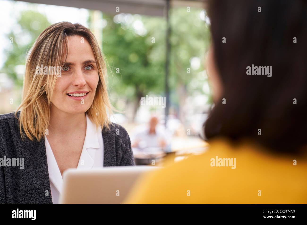 Vista frontale di una persona di lavoro femminile che parla con un collega Foto Stock
