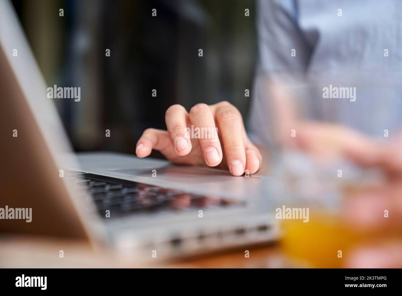 Primo piano della mano di una donna che scrive sul computer portatile in un ufficio all'aperto Foto Stock