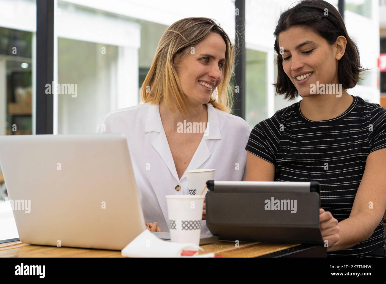 Media immagine di due diverse imprenditrici che lavorano con computer laptop e tablet digitale Foto Stock
