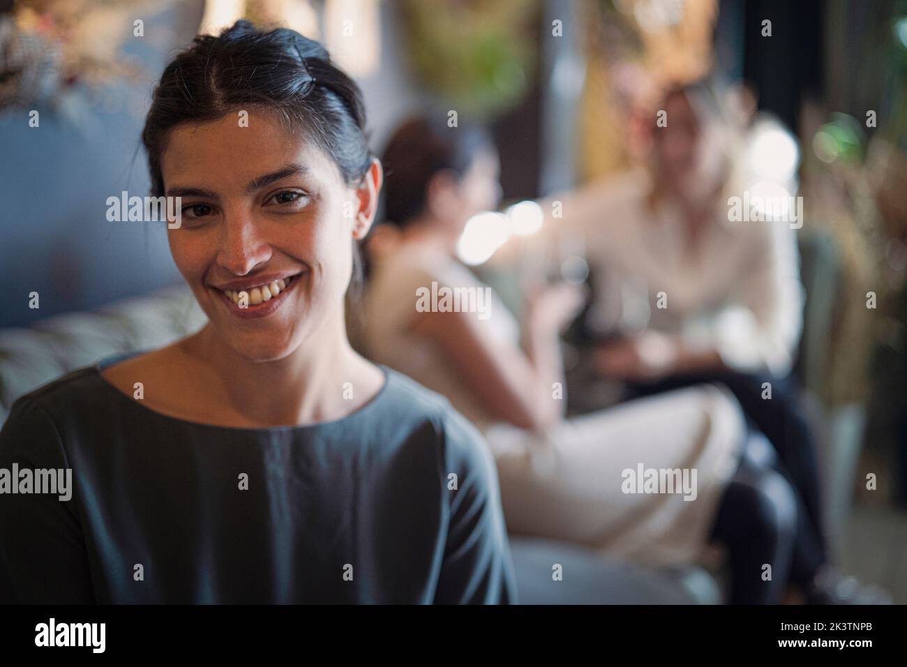 Ritratto di bella donna latino-americana guardando la fotocamera con le sue amiche sullo sfondo Foto Stock