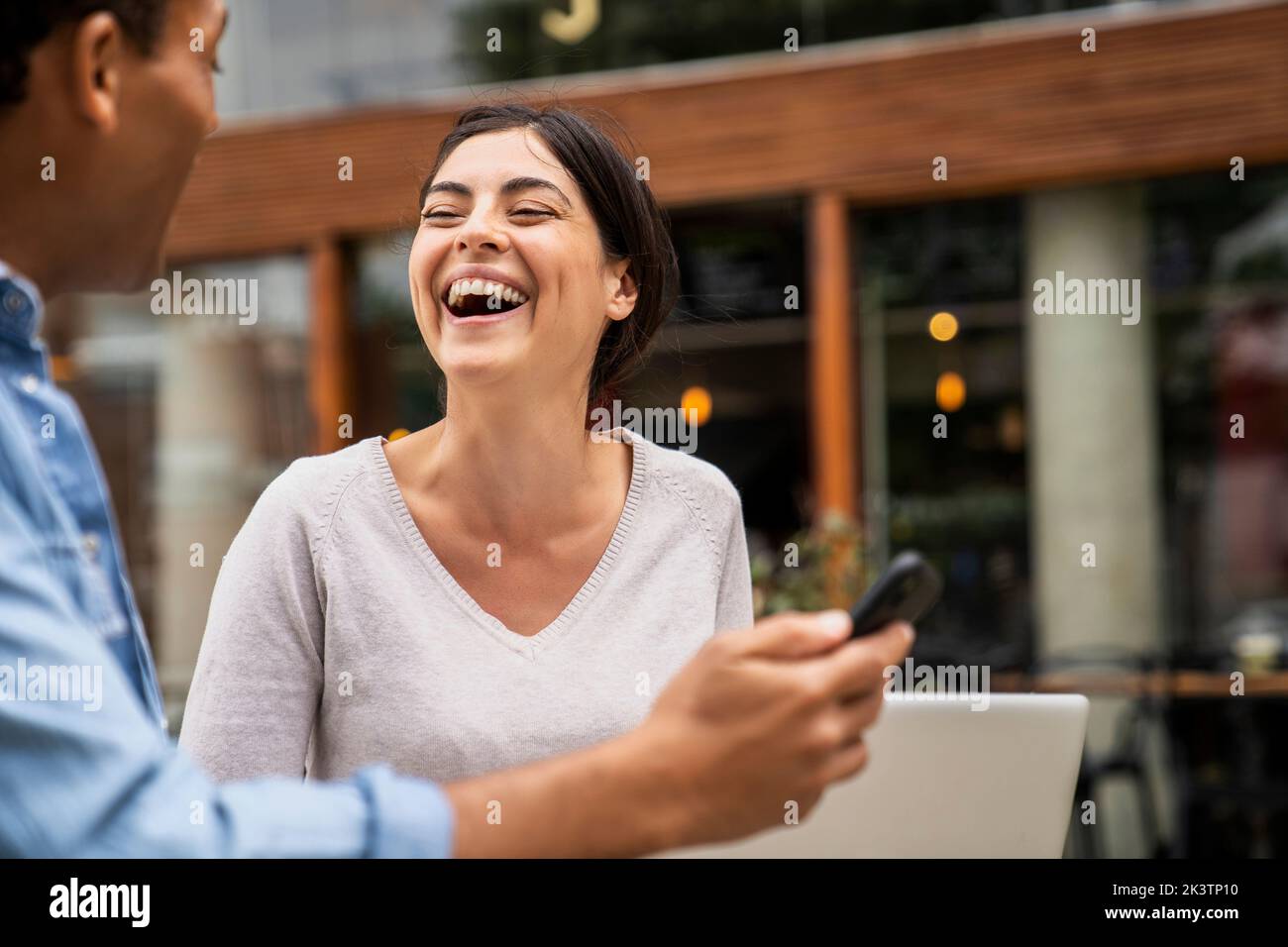 Side shot di coppia diversi che hanno un buon tempo e ridere con il loro contenuto online Foto Stock