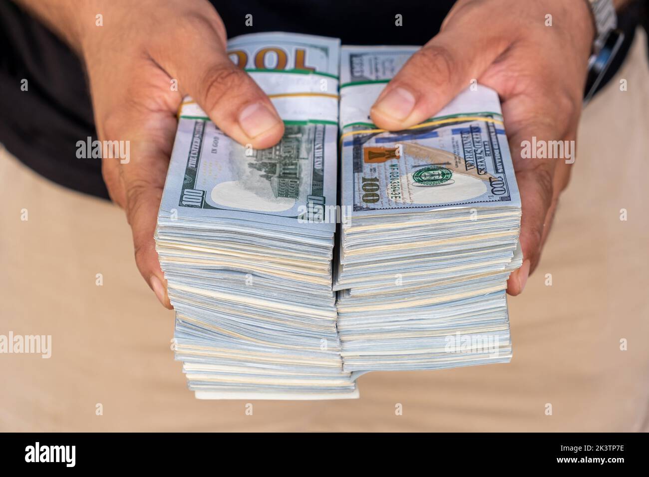 Pacchetti di dollari americani nelle mani di un uomo d’affari. Messa a fuoco selettiva Foto Stock
