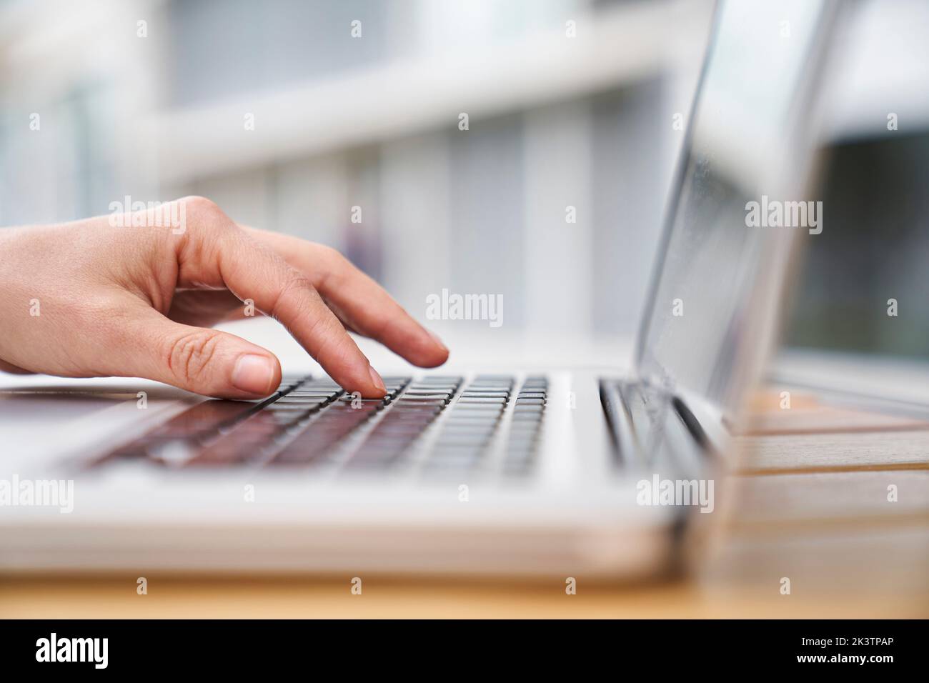 Primo piano immagine laterale della mano di una donna che digita su un computer portatile Foto Stock