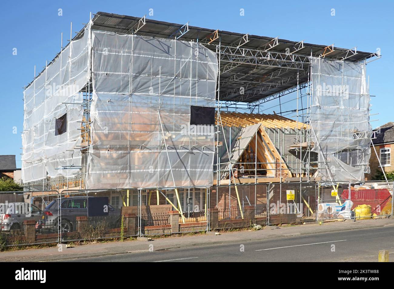Costruzione di edifici angolo sito bungalow conversione a casa racchiusa in bozzolo di plastica traslucido e corrugato tetto su impalcatura struttura UK Foto Stock