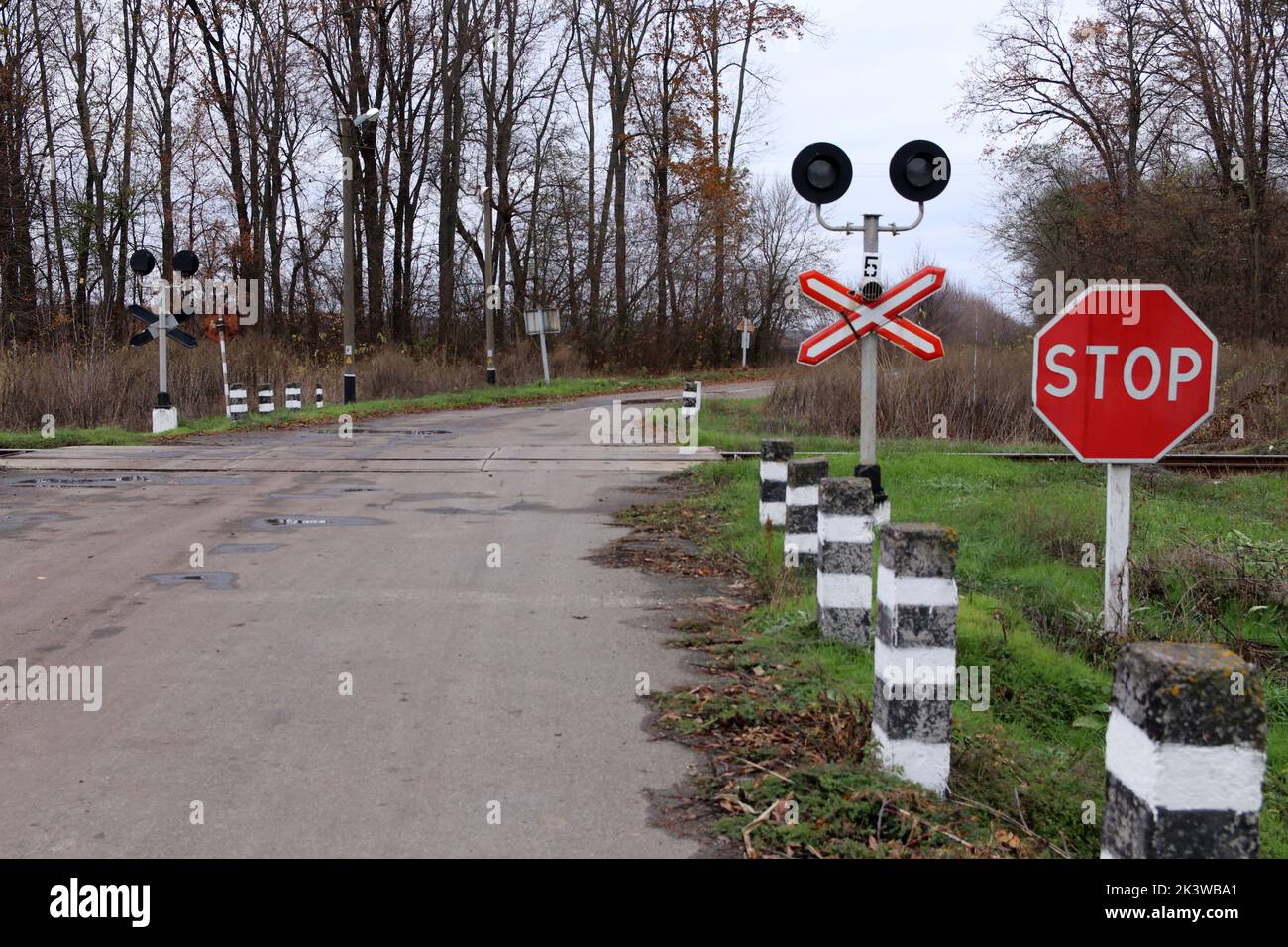 Attraversamento ferroviario con segnale di stop e semaforo. Foto Stock