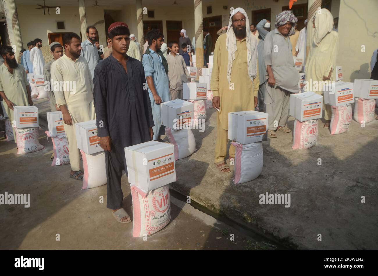 Peshawar, Pakistan. 22nd Set, 2022. Le persone colpite dalle inondazioni ricevono aiuti di soccorso distribuiti dalla Fondazione al Khidmat nel distretto di Nowshera, villaggio di Garhi Momin, provincia di Khyber Pakhtunkhwa a Peshawar, Pakistan il 22 settembre 2022. (Foto di Hussain Ali/Pacific Press/Sipa USA) Credit: Sipa USA/Alamy Live News Foto Stock