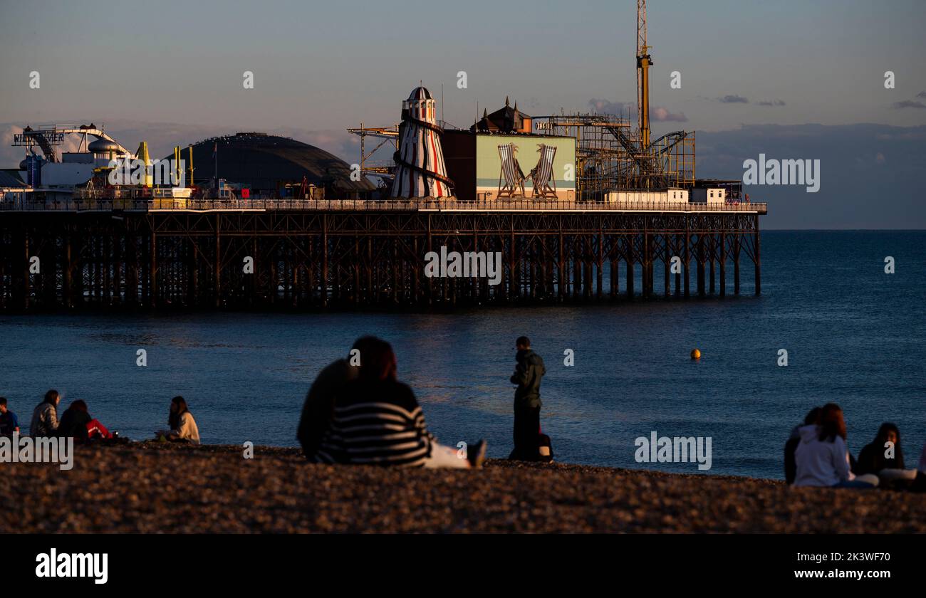 Brighton UK 28th settembre 2022 - i visitatori si riuniscono sulla spiaggia di Brighton per guardare il tramonto dopo una bella giornata autunnale lungo la costa meridionale . Tuttavia il tempo umido e ventoso è previsto per arrivare il Venerdì nel Regno Unito . : Credit Simon Dack / Alamy Live News Foto Stock