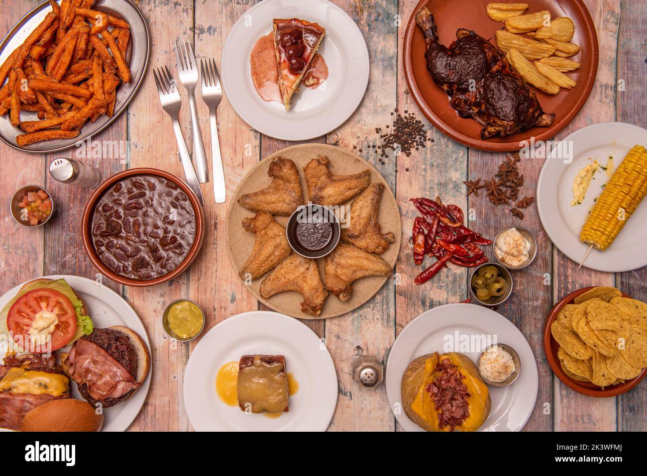 Deliziose ricette a base di fast food e snack con un sacco di patatine fritte, ali di pollo, hamburger, pollo al carbone, patate farcite, patata dolce fritta, chee Foto Stock