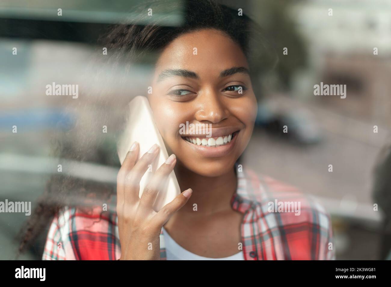 Ritratto di allegra donna afroamericana millenaria che parla con smartphone, godendosi del tempo libero Foto Stock