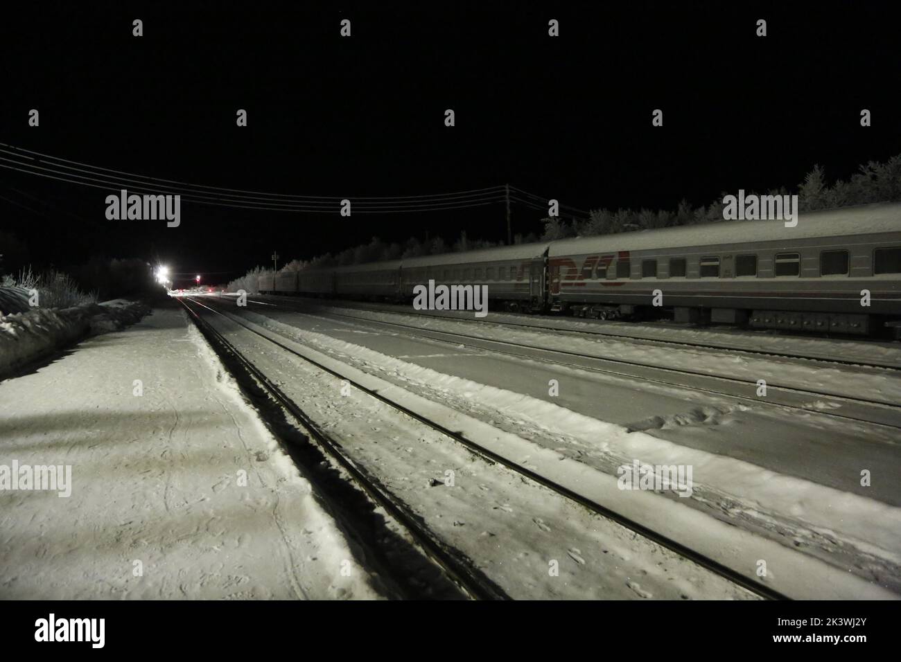 Vista sui binari ferroviari e sui vagoni ferroviari alla stazione Pyayve sul servizio ferroviario passeggeri più a nord del mondo tra Murmansk e Nikel nella notte polare Foto Stock