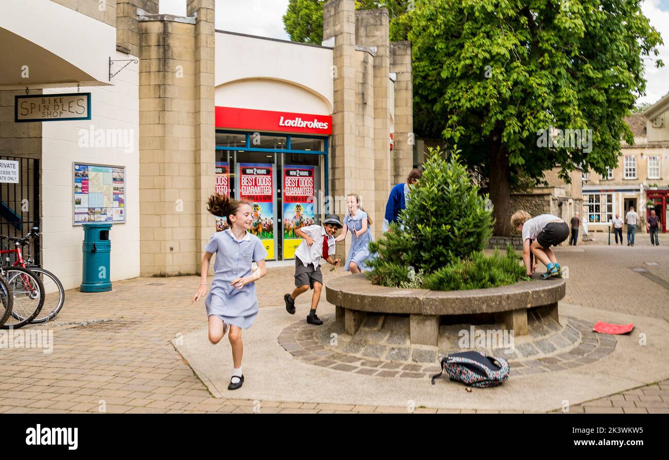 Street nella città mercato di Corsham Inghilterra, Regno Unito, che è stato utilizzato anche per la location delle riprese del dramma della BBC Poldark. I bambini giocano per strada. Foto Stock
