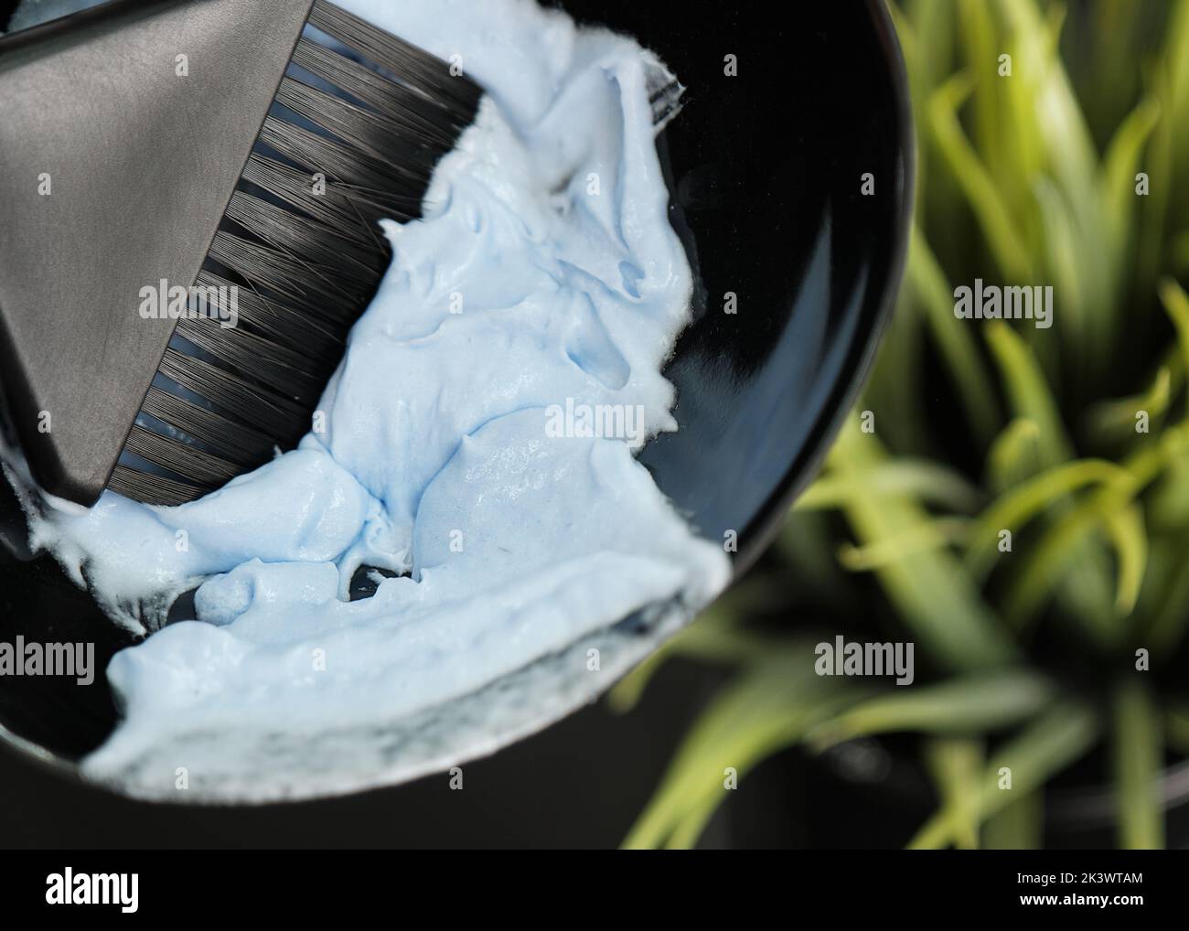 Il parrucchiere inginocchia la tintura per capelli nel salone. Processo di colorazione dei capelli Foto Stock