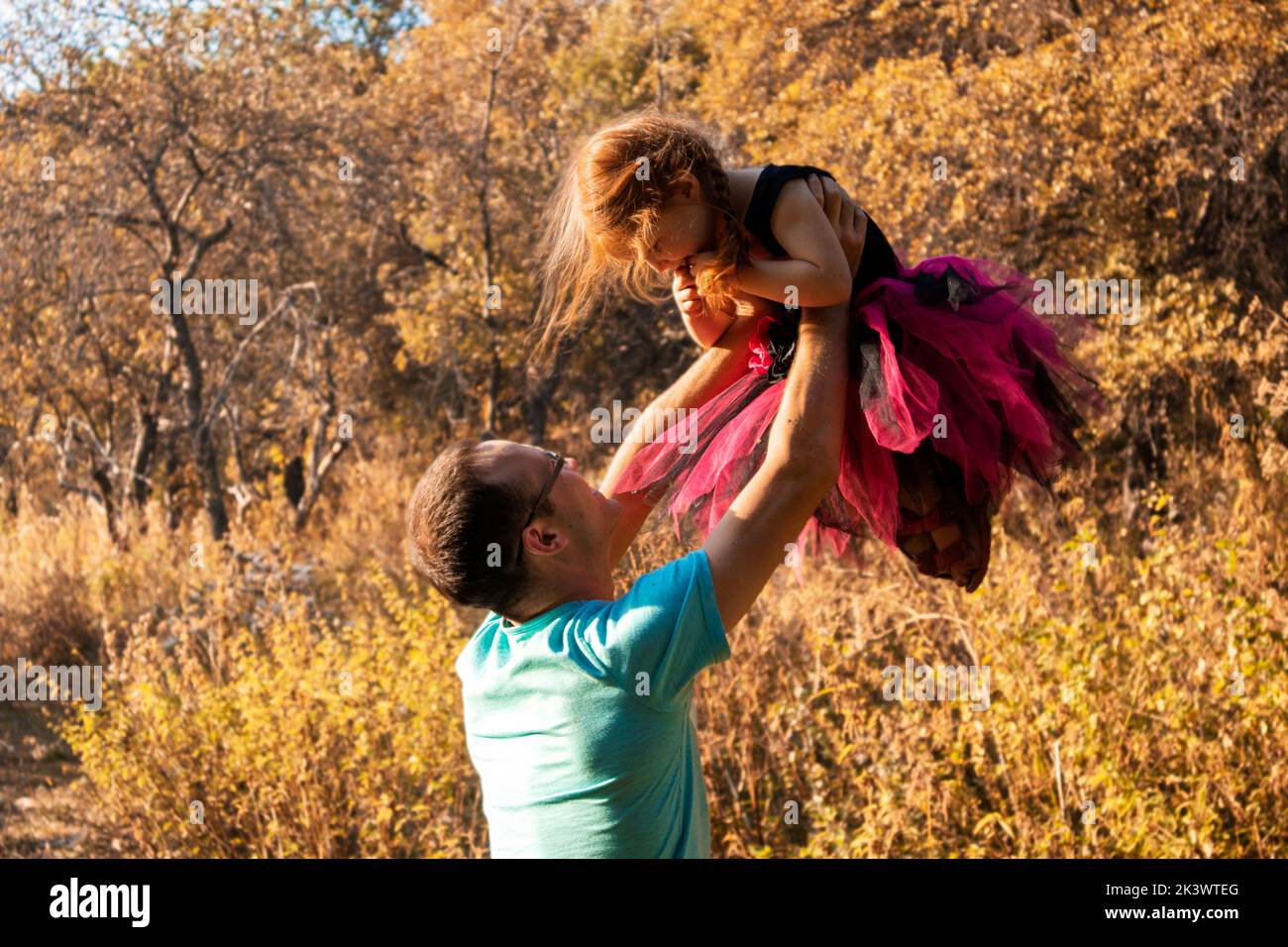 papà e figlia stanno ballando in nature.a ballerina piccola danze con suo papà. principessa piccola.papà tiene la sua figlia tra le braccia. danza sostegno Foto Stock