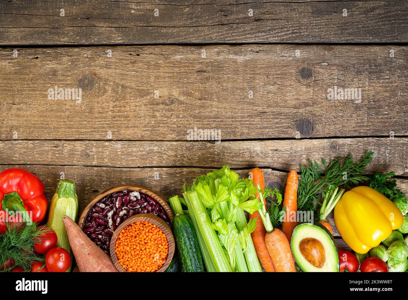 Sfondo cibo sano. Verdure fresche, frutta, fagioli e lenticchie su tavola di legno. Cibo vegetariano. Cibo sano, dieta, vegan e mangiare sano co Foto Stock