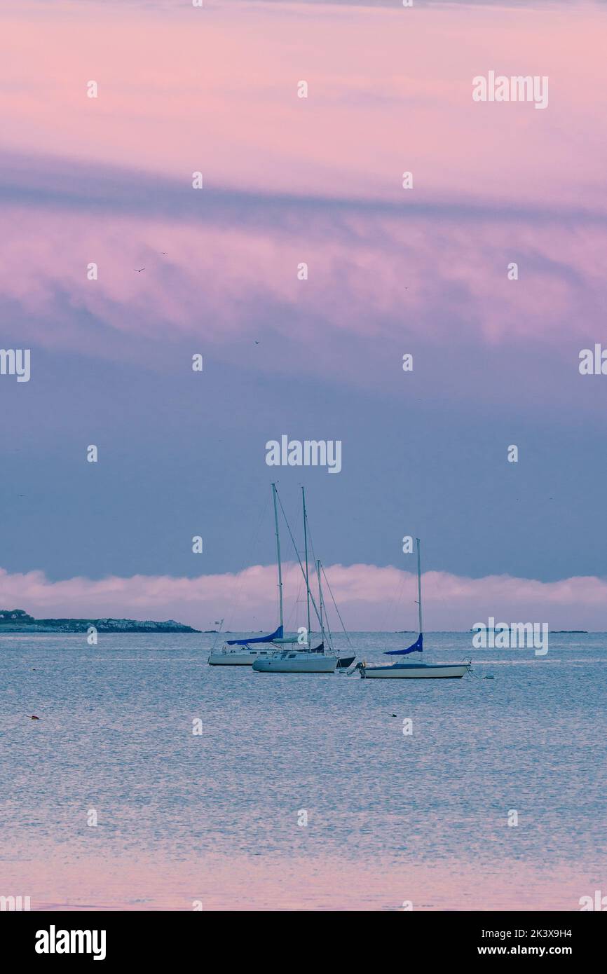 Pastello Rainbow Sky con barche ormeggiate e isola Foto Stock