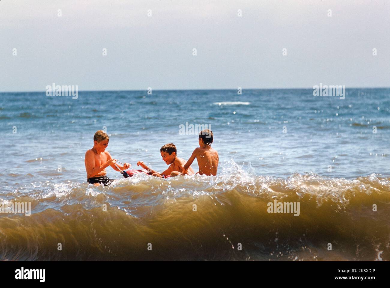 Tre ragazzi che giocano a Ocean at Beach, Southampton, New York, USA, toni Frissell Collection, Agosto 1956 Foto Stock