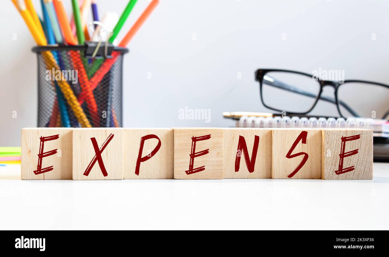 SPESE - denaro in euro e parola su un tavolo di legno bianco, notebook, blocco note. Concetto aziendale: Acquisto, vendita Foto Stock