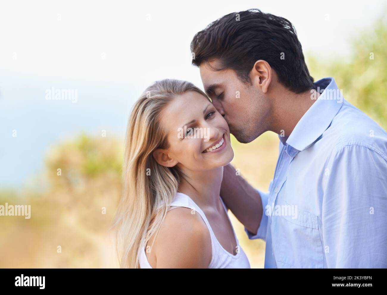 Posso solo ottenere abbastanza di voi. Un bel giovane che dà alla sua ragazza un bacio mentre si levano in piedi fuori. Foto Stock