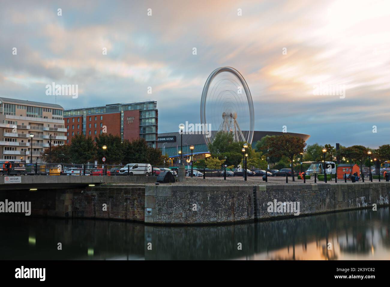 Otturatore lento esposizione lunga della ruota Grande all'Albert Dock Liverpool poco prima del tramonto Foto Stock