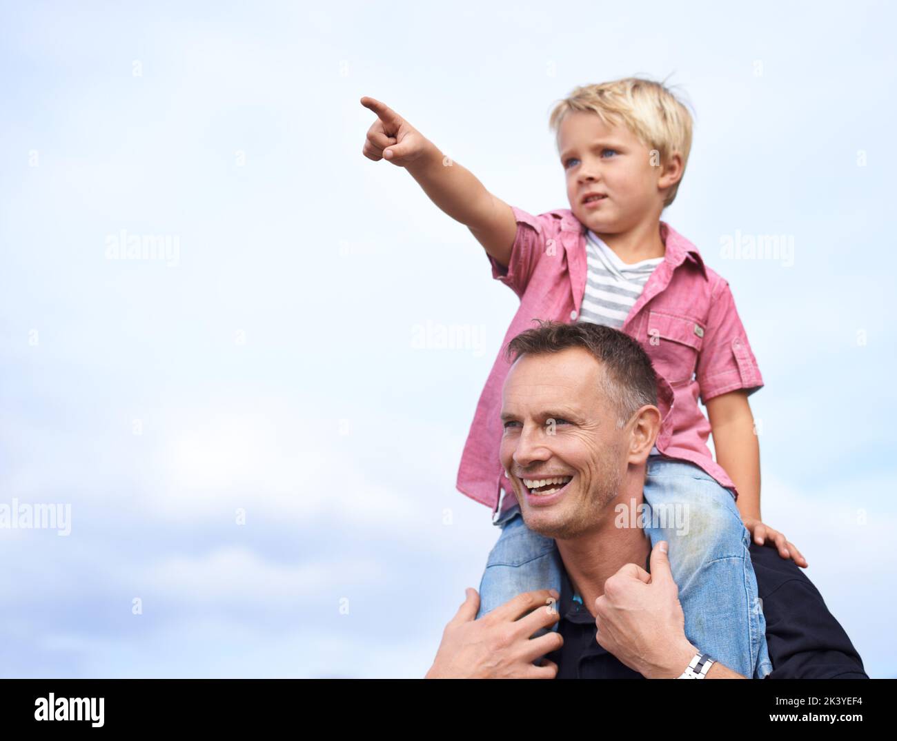 Godendo suo papà con papà. Un bel padre che porta il figlio sulle spalle. Foto Stock