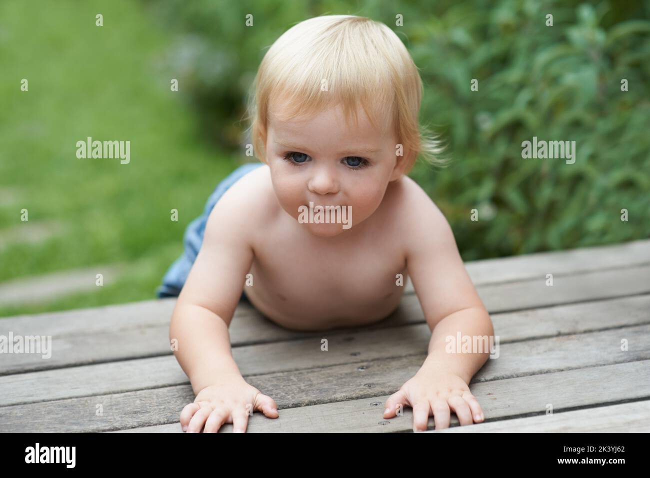 HES un bambino curioso. Un bambino dolce che strisciare fuori. Foto Stock