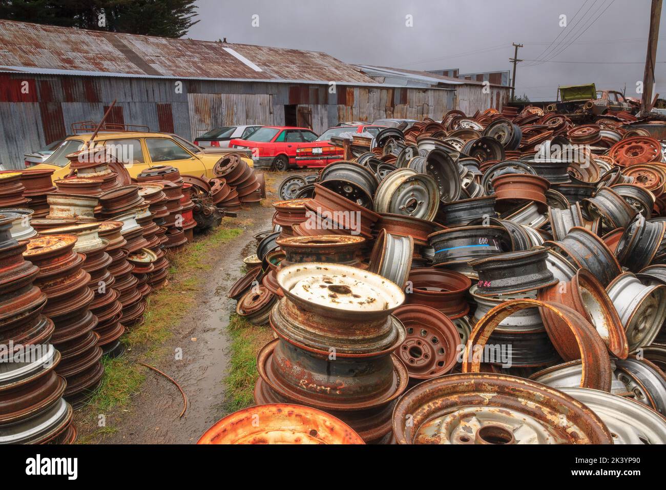 Mucchi di ruote di automobile dalle automobili scartate al cantiere di un relitto. 'Smash Palace', Horopito, Nuova Zelanda Foto Stock