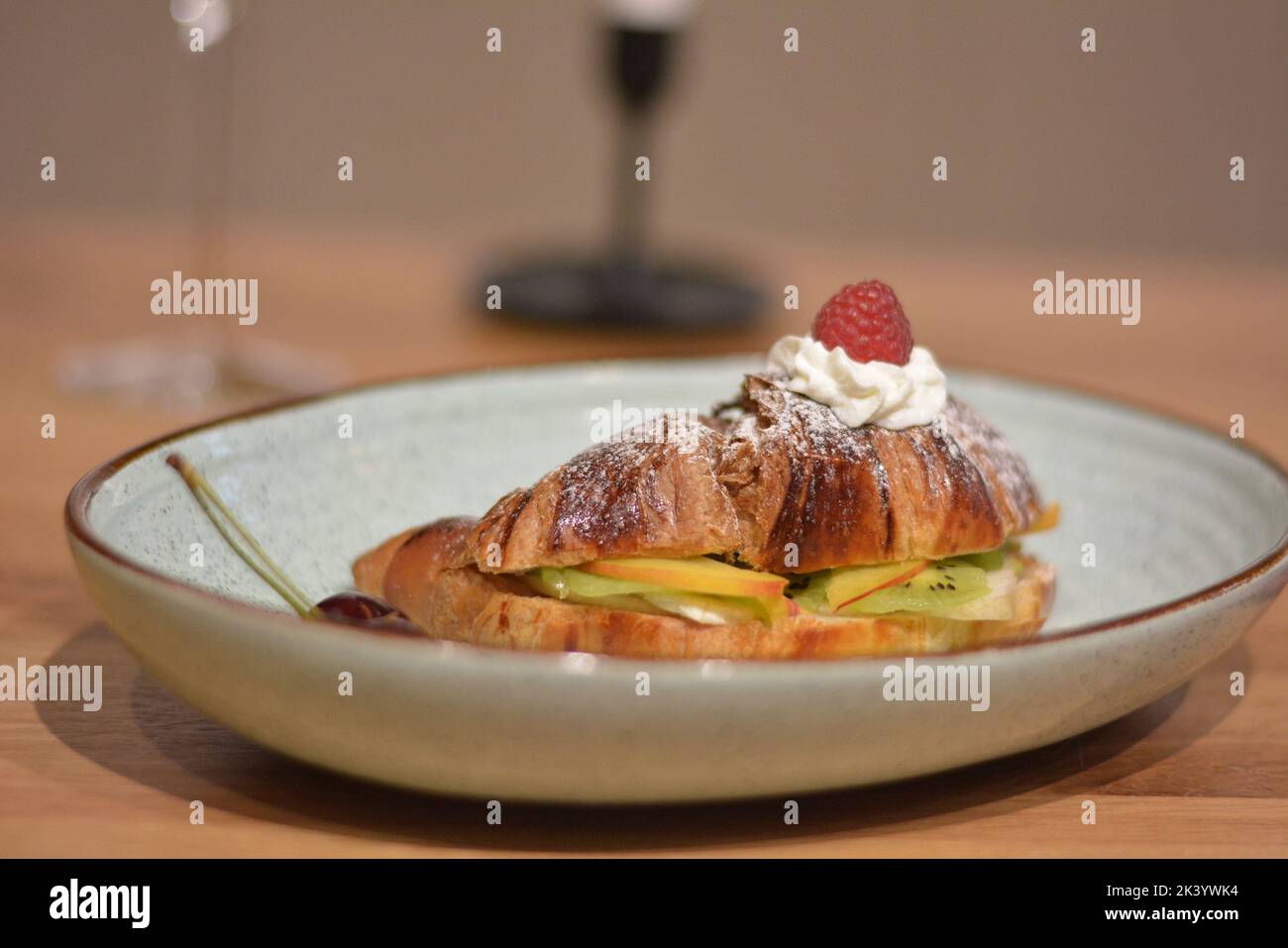 Croissant dolci e fette di frutta sul tavolo, primo piano. Foto Stock