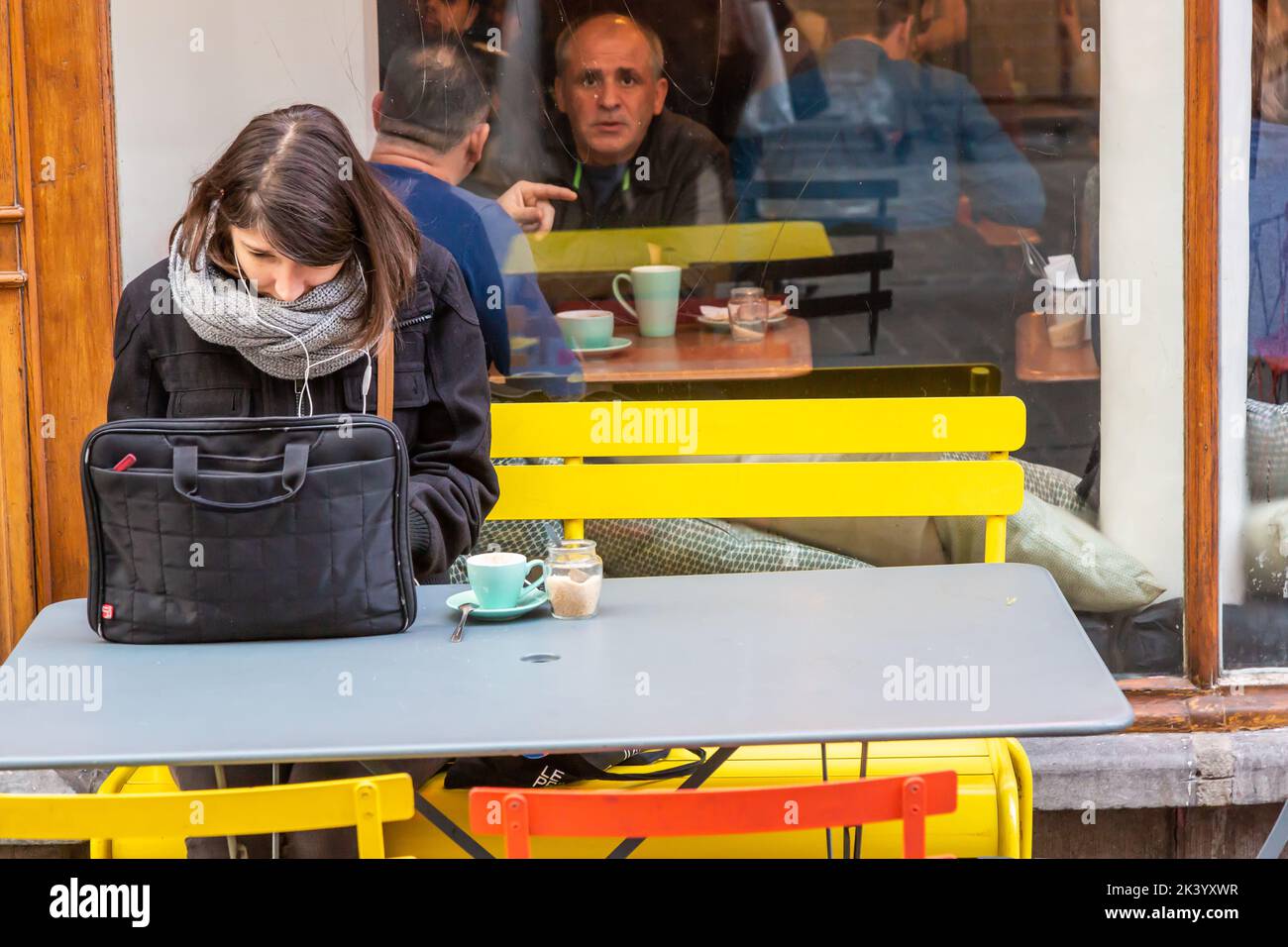 Giovane donna che ha un caffè mentre consulta il suo giro superiore. Bruxelles. Foto Stock