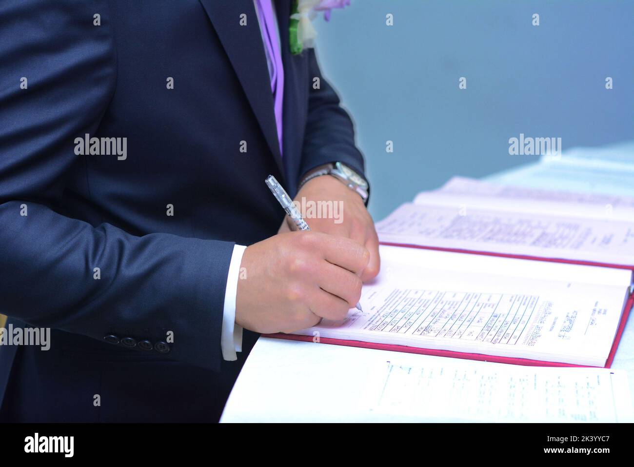 Lo sposo firma i documenti di matrimonio. Foto Stock