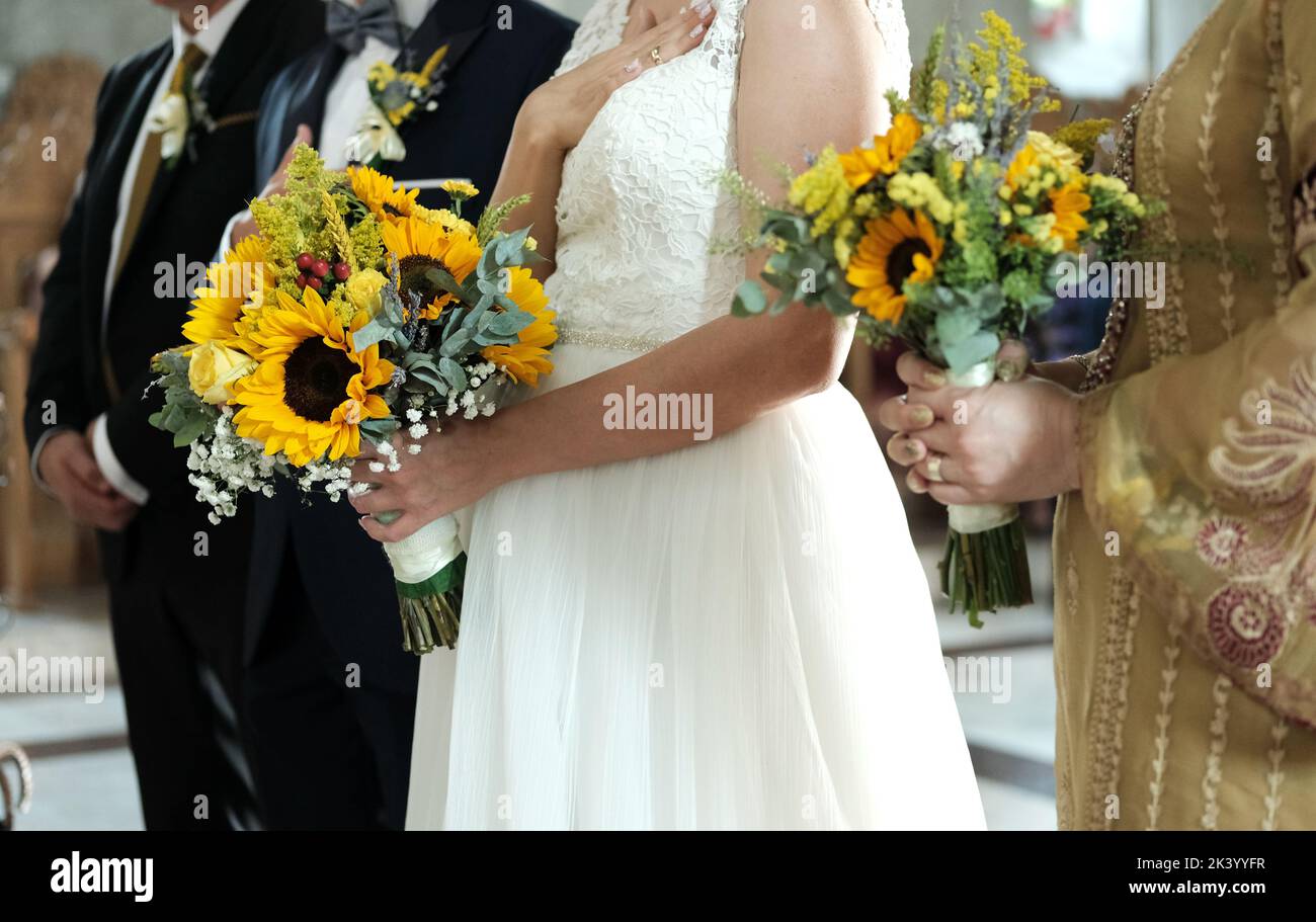 La sposa e sposo nella chiesa. Il girasole fa parte del tema delle nozze. Foto Stock