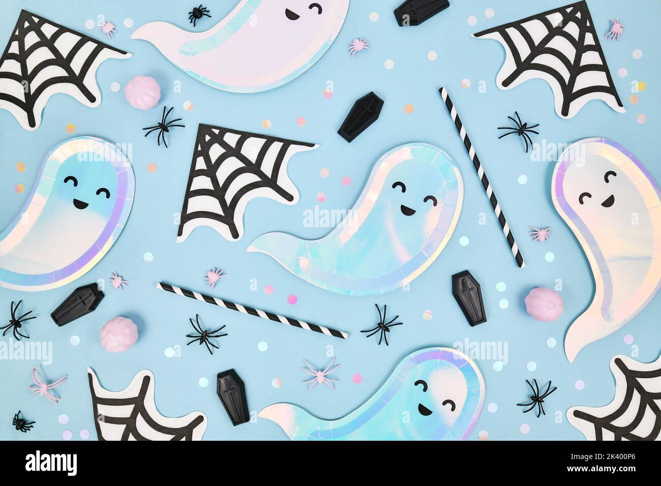 Grazioso piatto di Halloween colorato pastello con piatti a forma di fantasma, tovaglioli ragno e coriandoli su sfondo blu Foto Stock