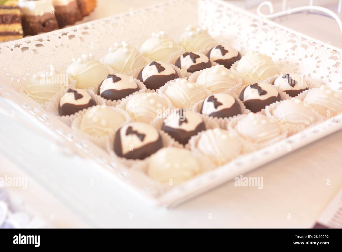 Torte rotonde per matrimoni con perle bianche e fiocco maschio. Torte per sposi e sposi. Foto Stock