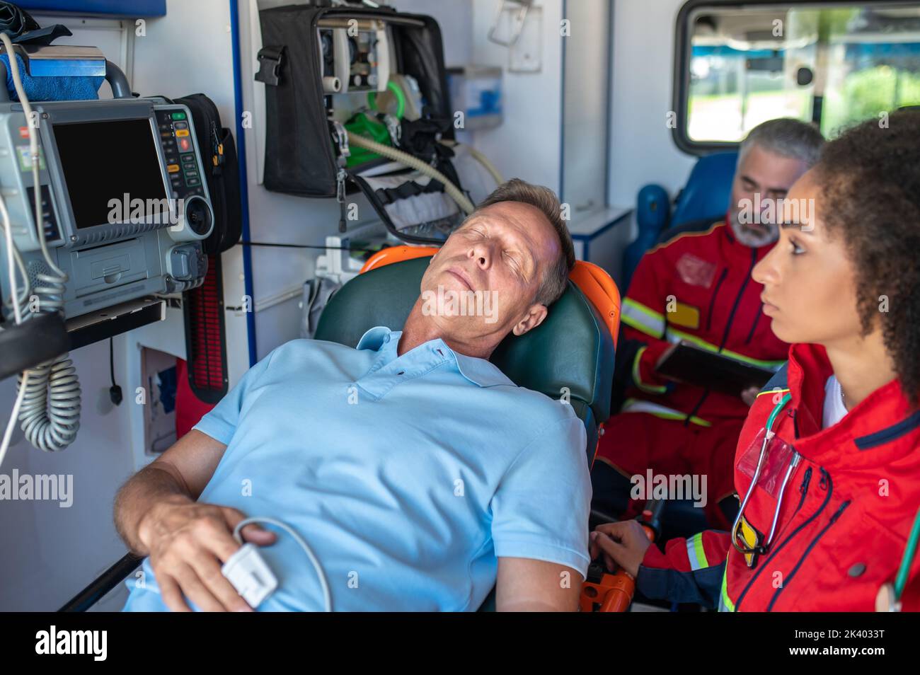 Personale paramedico che trasporta l'uomo ferito in ospedale Foto Stock