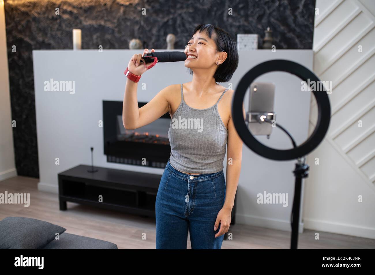 Allegra cantante asiatica che ha eseguito una canzone al suo pubblico digitale Foto Stock
