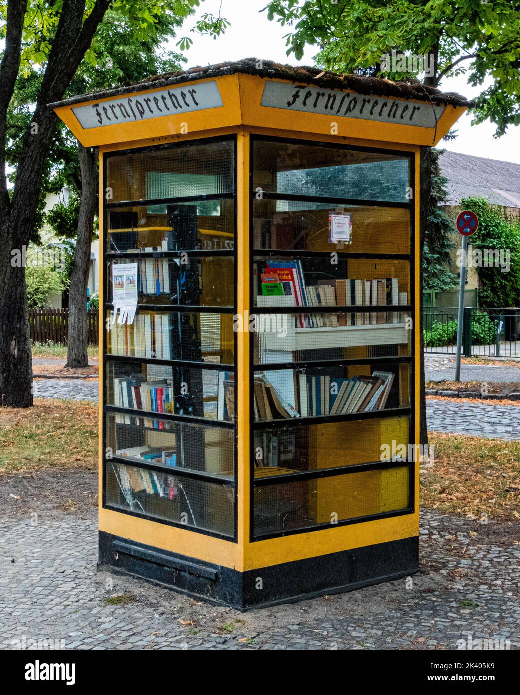 Vecchia cassetta telefonica gialla ora una piccola biblioteca di prestito, Lübars, Reinickendorg, Berlino Foto Stock