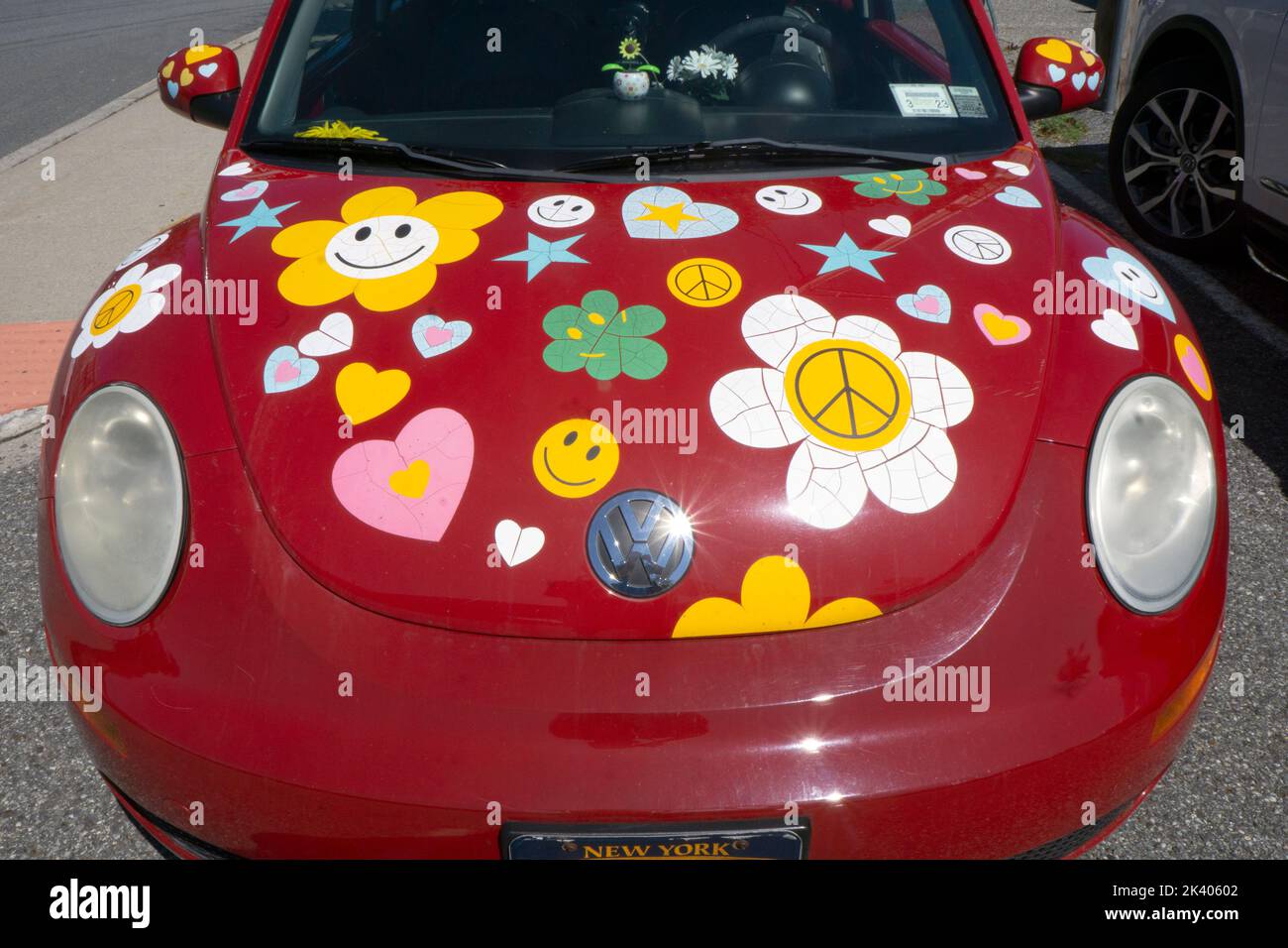 Un bug rosso Volkswagen 2010 coperto da adesivi che ricordano gli anni '1960s. In un parcheggio a Chappaqua, New York. Foto Stock