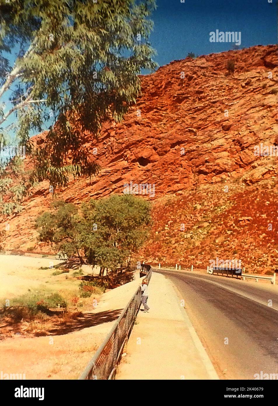 1972 Un ragazzino sottolinea le dimensioni delle MacDonnell Ranges circostanti al Gap che conduce ad Alice Springs, Northern Territory, Australia Foto Stock