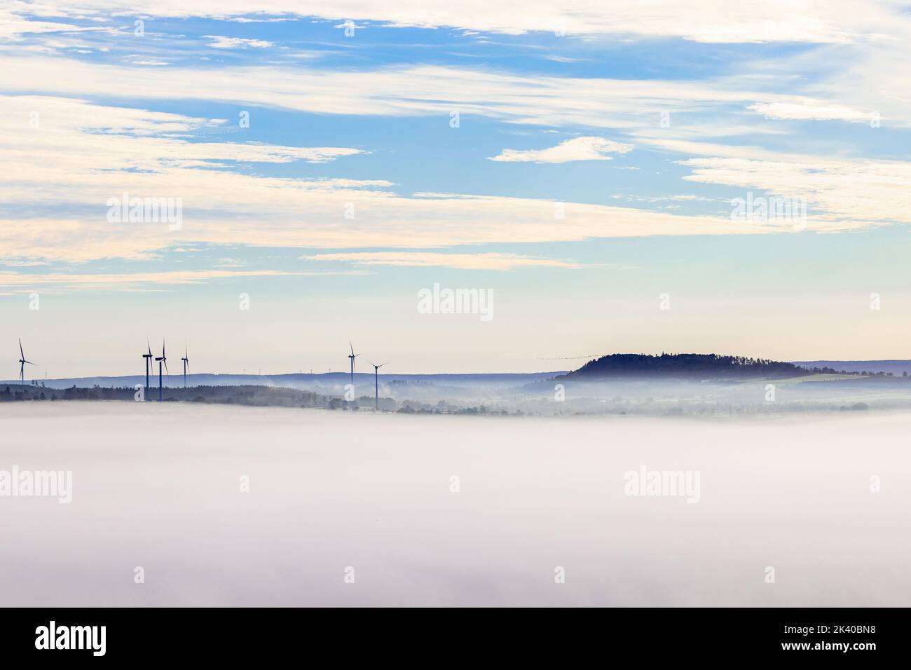 Parco eolico in una vista di paesaggio nebbiosa e ondulata Foto Stock