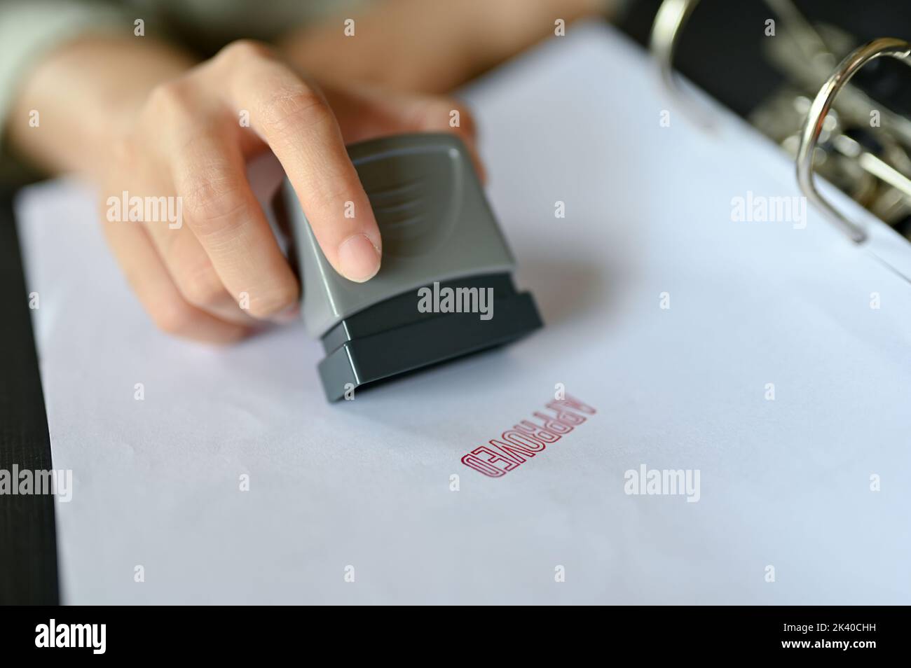Una donna d'affari professionale ha approvato una proposta commerciale con un timbro di gomma su un documento. Immagine ravvicinata Foto Stock